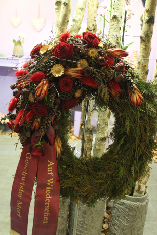 Trauerkranz winterlich ausgeschmückt mit roten Rosen 
